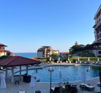 A view of the pool with surroundings and the sea in the town of Sveti Vlas, surrounded by sunbeds.