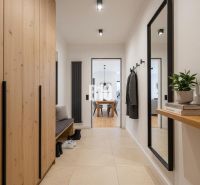 A wardrobe with a large mirror in a 4-room apartment with a wooden decor floor.