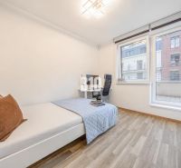 A room in a 3-room apartment with a bed, a desk, and a floor with a wooden decor.
