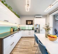 A kitchen with white cabinets and a wood-patterned floor in a 3-room apartment.