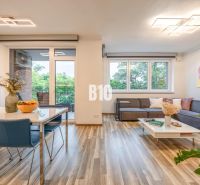 Living room with wood-patterned flooring, sofa, and dining table in a 3-room apartment.