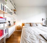 A bright bedroom with built-in shelves and a wooden decor floor in a 3-room apartment.