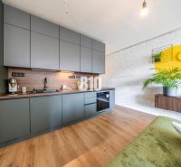 A kitchen in a 3-room apartment with dark cabinets, a wooden decor floor, and yellow decorations.