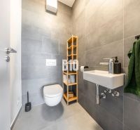 A bathroom in a 3-room apartment with modern gray tiles and a wall-mounted toilet.