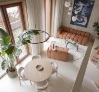 A bright living room with a round table and artificial flooring in a two-room apartment.