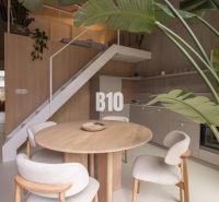 Interior of a 2-room apartment with a round table and wooden decor flooring.