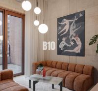Living room in a 2-room apartment with comfortable sofas and an artistic painting on the wall.