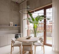 Dining area with a plant and glass doors in a 2-room apartment.