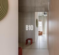 Mirrored doors in a 2-room apartment with a minimalist design and a concrete ceiling.