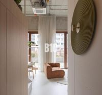Interior of a 2-room apartment with a comfortable armchair, large windows, and modern decorations.