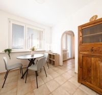 Dining area with a table, chairs, and a wooden cabinet in a 3-room apartment.