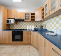 Kitchen unit with storage space, microwave, stove, and tiled backsplash in a 3-room apartment.