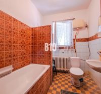 A bathroom in a family house with colorful tiles and a bathtub.