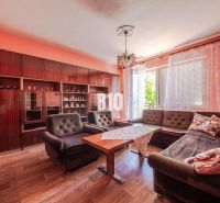 Living room in a family house with a sofa, furniture, and wooden decor flooring.