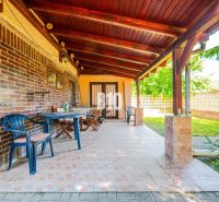 The terrace of a family house in Branč with plastic furniture and a wooden ceiling.