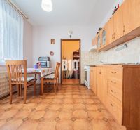 A kitchen in a 3-room apartment with wooden cabinets and a dining nook.