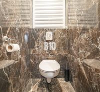 Luxury bathroom in a 3-room apartment with marble tiles and a toilet.