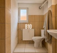 A bathroom in a two-room apartment with beige tiles.