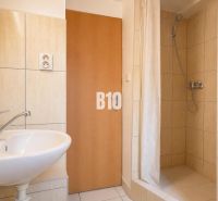 Bathroom with tiles and a shower in a 2-room apartment.