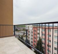 The balcony of a 2-room apartment in Bánovce nad Bebravou with tiles and a view of the surroundings.
