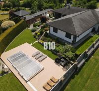 A family house in Súľov-Hradná with a terrace, swimming pool, and garden surrounded by greenery.