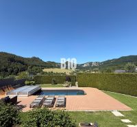 A swimming pool in the garden of a family house in Súľov-Hradná with a view of the surrounding mountains.