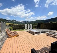 The terrace of a family house in Súľov-Hradná with a view of the mountains and a pool.