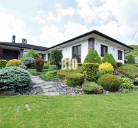 A family house in Súľov-Hradná with a well-maintained garden and a stone walkway.