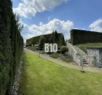 A garden at a family house in Súľov-Hradná with a well-maintained lawn and a hedge.