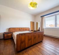 A bedroom in a family house with a wooden decor floor and retro furniture.