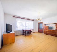Living room in a family house with a wooden decor floor, furniture, and a television.