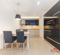 Kitchen area in a 2-room apartment with a dining table and kitchen unit.