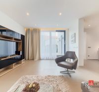Living area in a 2-room apartment with a television and a comfortable armchair.