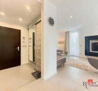 Interior of a 2-room apartment with a wooden decor floor, sofa, and television.