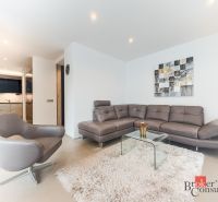 Living room in a 2-room apartment with a leather sofa and a glass table.