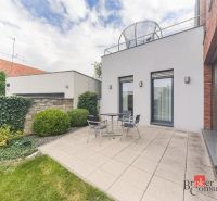 Terrace of a 2-room apartment with tiles, seating area surrounded by a green garden on Bárdošova Street.
