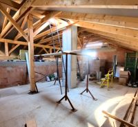 The attic of a family house with wooden beams and construction materials in the interior.