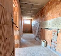 Interior walls in a brick family house under construction with a concrete ceiling.