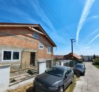 A family house at Lehárova 2 in Nitrianske Hrnčiarovce with parked cars and a blue sky.