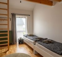 A room with a bright interior, beds, and a wooden decor floor in a 4-room apartment.