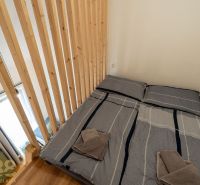 A bedroom in a 4-room apartment with a wooden structure and a bed with shirt-patterned bedding.