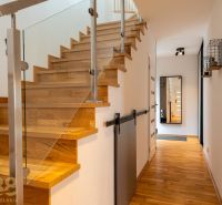 A hallway with stairs, a wooden decor floor, and a mirror in a 4-room apartment.