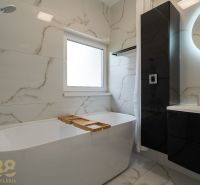 A bathroom with a shower, bathtub, and marble tiles in a 4-room apartment.