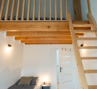Loft bed with a wooden ladder and floor with a wooden decor in a 4-room apartment.