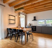A kitchen in a 4-room apartment with a dining table and a wooden-patterned floor.