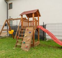 A children's climbing frame with a slide and a swing in the yard of a 4-room apartment on Vodárenská Street in Nová Lesná.