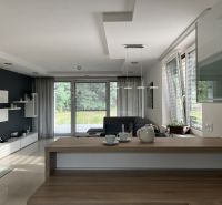 Living room in a family house with a sofa, glass doors, and modern furniture.