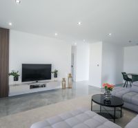 Living room in a family house with a TV on the wall and comfortable seating.