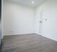A room in a family house with a wooden decor floor and blinds.