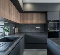 A kitchen in a family house with dark cabinets and a wood-patterned floor.